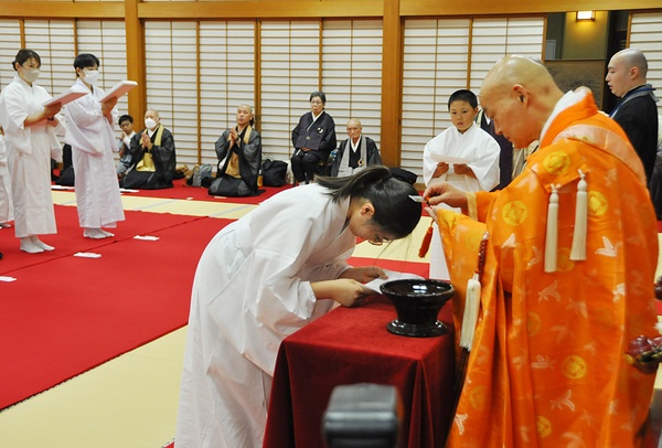 剃髪の儀で山川管長から頭に剃刀を当てられる沙弥