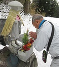 お大師さんも冬支度　岐阜・駒月氏　峠道の石像に蓑