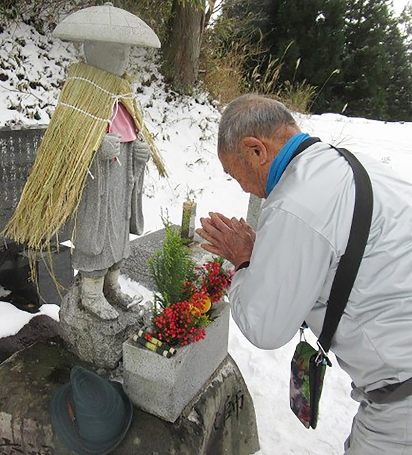 お大師さんも冬支度　岐阜・駒月氏　峠道の石像に蓑