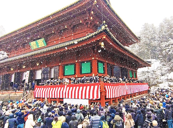 雪の舞う中、三仏堂の回廊から行われた「縁喜がらまき」