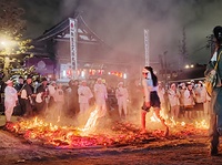 火まつり・火渡り神事で火の中を進む参加者