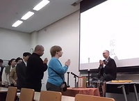 谷山教授と合掌礼を交わす生前葬の参加者
