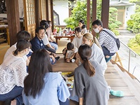 「お寺でのんびり過ごす日」の一こま。中平住職（左から3人目）を中心に参加者が境内で自由に過ごす