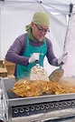 輪島市の温泉施設で開いた炊き出しで焼きそばを焼く石﨑住職(2025年11月)
